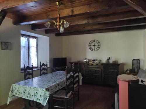 une salle à manger avec une table et une horloge au mur dans l'établissement Gîte du Mont, à Saint-Hippolyte