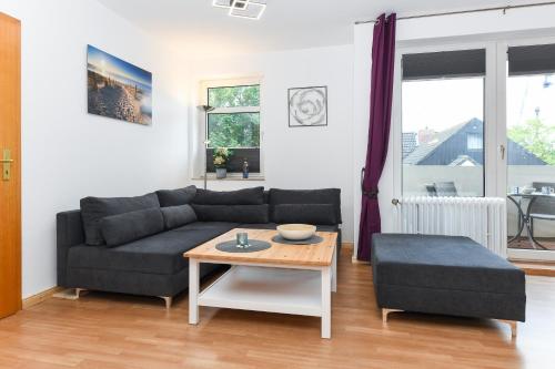sala de estar con sofá y mesa en Ferienwohnung Strandmuschel, en Carolinensiel