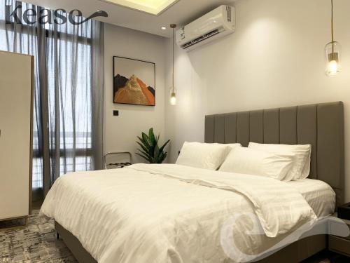 a bedroom with a large bed with white sheets at Kease Malqa B-11 Royal touch AZ60 in Riyadh