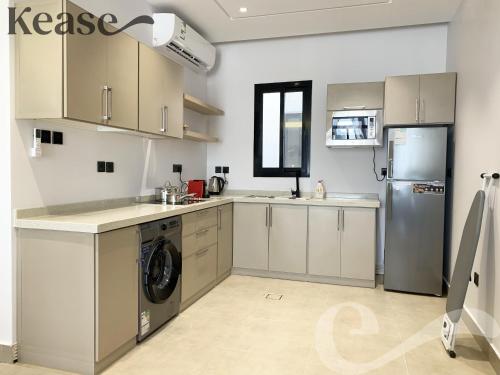 a kitchen with a refrigerator and a washer and dryer at Kease Malqa B-11 Royal touch AZ60 in Riyadh
