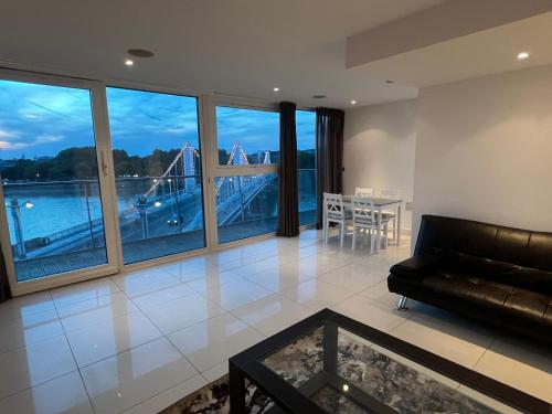 a living room with a couch and a view of a bridge at Best Location Chelsea River View /Central London in London