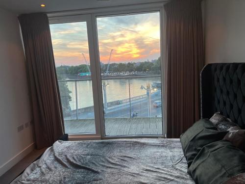 a bedroom with a large window with a view of a river at Best Location Chelsea River View /Central London in London