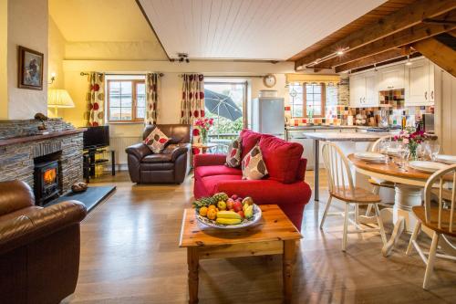 a living room with a red couch and a table at Croft Farm & Celtic Cottages in Cardigan