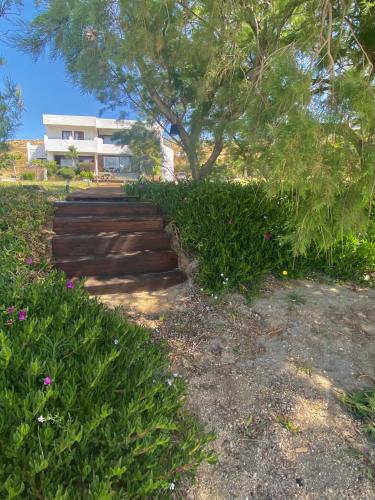a set of stairs in front of a house at Svolis Beachhouse - Villa Set in a Beautiful Bay in Karistos