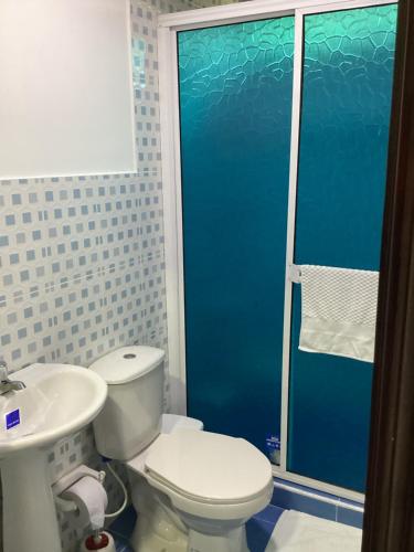 a bathroom with a toilet and a sink and a shower at Honey Hill View in San Andrés