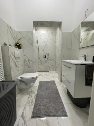 a white bathroom with a toilet and a sink at Herne Zentral Apartment in Herne