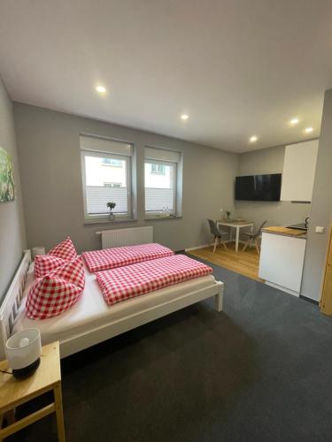 a bedroom with a bed with red and white pillows at Pension Ratsgasse in Weißensee