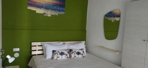 a green bedroom with a bed and a surfboard on the wall at Ilio Socrates in Skala Marion