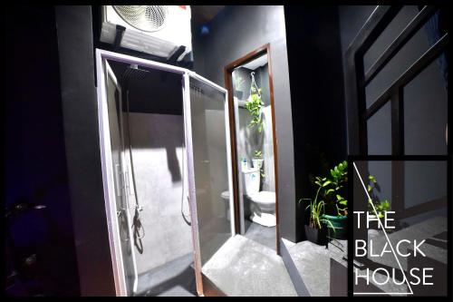 ein Bad mit einer ebenerdigen Dusche und einem WC in der Unterkunft The Black House in Dulong Bayan