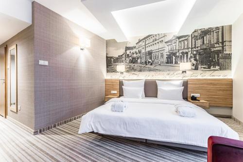 ein Schlafzimmer mit einem großen weißen Bett in einem Zimmer in der Unterkunft Hotel Wieniawski in Lublin