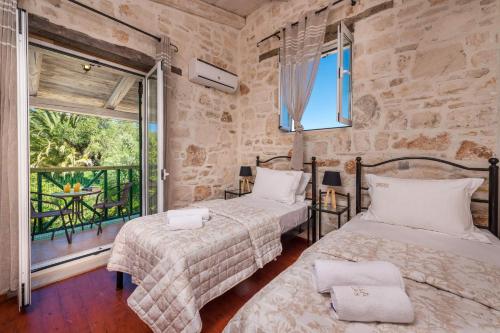 a bedroom with two beds and a balcony at Villa Rizolia Epta by Villa Plus in Lithakia