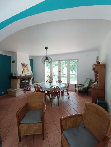 un salon avec une table et des chaises dans l'établissement Maison dans le centre de messanges, à Messanges