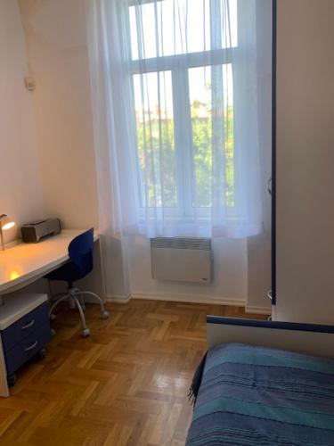 um quarto com uma secretária, uma cama e uma janela em Apartman Villa Klein em Opatija