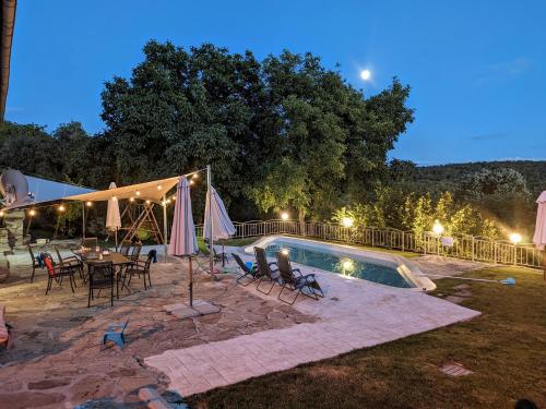 - une piscine avec des tables, des chaises et une table avec des parasols dans l'établissement Villa Girgina, à Bukovets