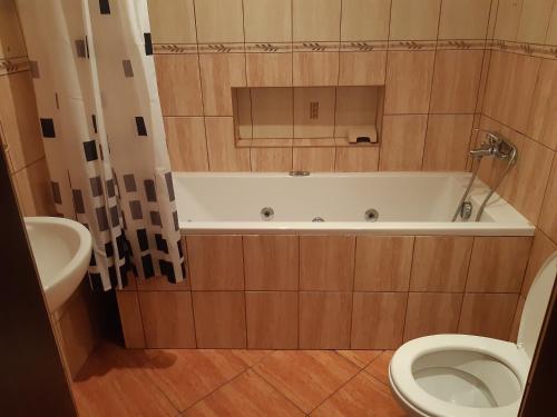a bathroom with a tub, toilet and sink at Bogdanka in Jastrzębia Góra