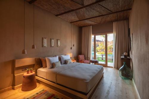 阿拉恰特的住宿－Pachamama Alaçatı，一间卧室设有一张大床和一个大窗户