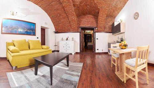 a living room with a yellow couch and a table at Dom Unirii Apartment in Timişoara