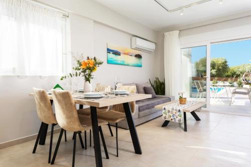 a dining room with a table and chairs and a couch at Villa Vilenia Horizon by Villa Plus in Katastárion