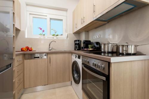 a kitchen with a stove and a dishwasher at Villa Vilenia Horizon by Villa Plus in Katastárion