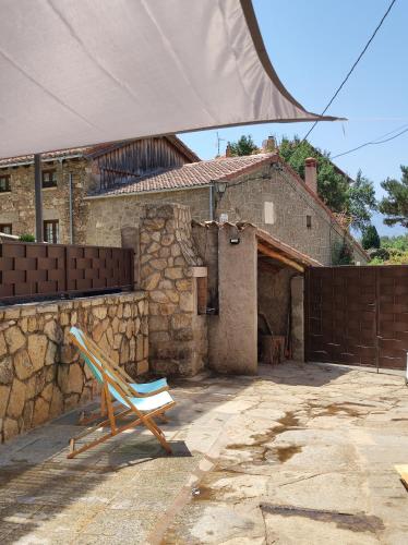 a chair sitting in front of a house at CASA RURAL EL TOLEO in Hoyos del Espino