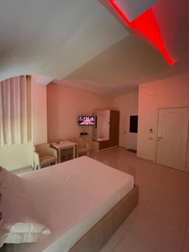 1 dormitorio con cama, mesa y TV en Grand Hotel Gjyshi, en Qerrexhias
