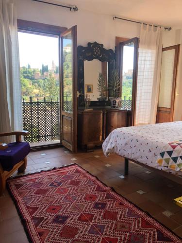 a bedroom with a bed and a large window at Alhambra en el Sacromonte in Granada