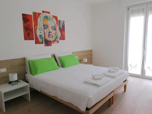 a bedroom with a large white bed with green pillows at Casa vacanze Sissi in Arco