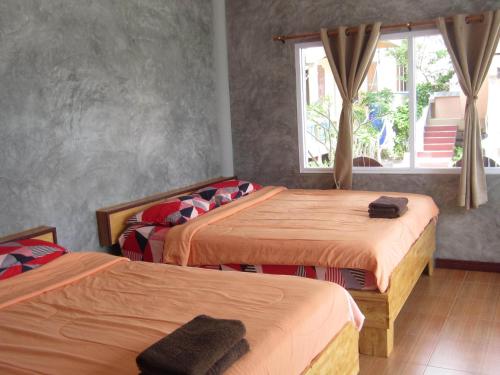 a bedroom with two beds and a window at Charung Beach in Haad Rin