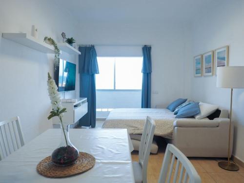 ein Wohnzimmer mit einem Tisch und ein Zimmer mit einem Bett in der Unterkunft Apartamento Horizonte El Puertito de Güímar in Puertito de Güímar