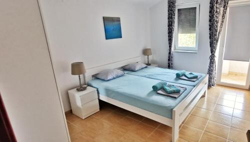Schlafzimmer mit einem Bett mit blauer Bettwäsche und einem Spiegel in der Unterkunft Apartment Cota in Vinkuran