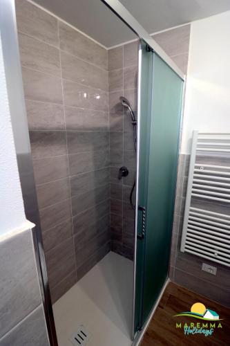 a shower with a glass door in a bathroom at M.H Bovio Apartment in Follonica