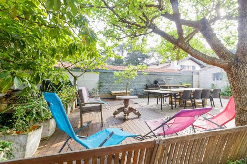 una terraza con sillas, una mesa y un árbol en Le Doolie's Biarritz - Siquijor Habitación privada - Jardín - Salón, en Biarritz