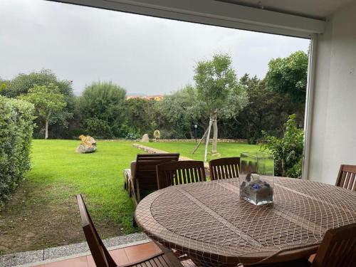 a table and chairs with a view of a yard at Residenze Coda Cavallo in San Teodoro