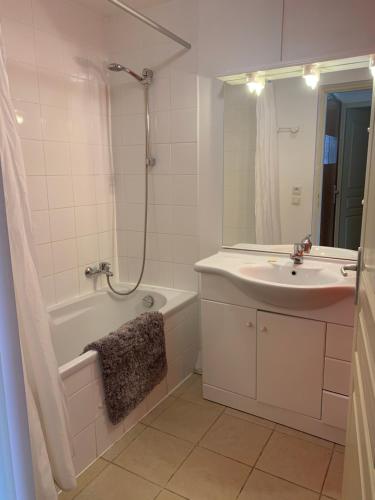 a bathroom with a sink and a tub and a shower at Appartement T2 Centre Valberg in Valberg