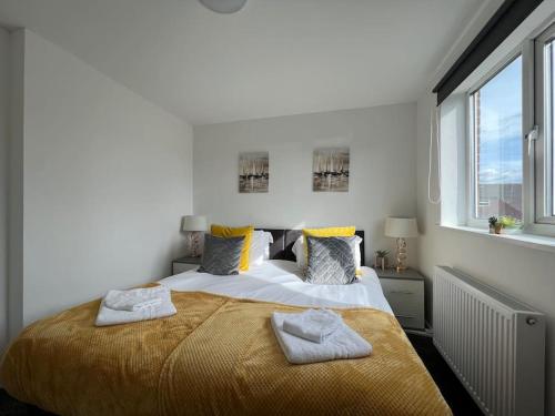 a bedroom with a large bed with two towels on it at Location-Comfortable Beds-Free Parking-Families in Nottingham