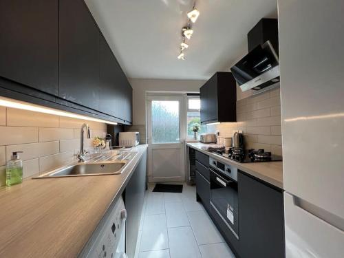 uma cozinha com um lavatório e uma bancada em Location-Comfortable Beds-Free Parking-Families em Nottingham