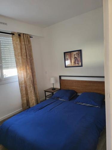 um quarto com uma cama azul e uma janela em 09Launay Bouhier 09 em Nantes