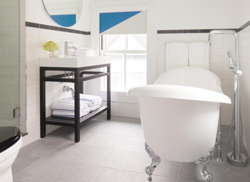 a bathroom with a white tub and a sink at The Chequit in Shelter Island Heights