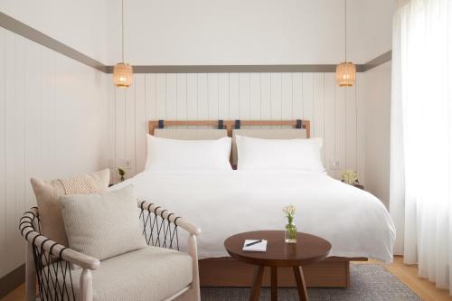 a bedroom with a bed and a chair and a table at The Chequit in Shelter Island Heights