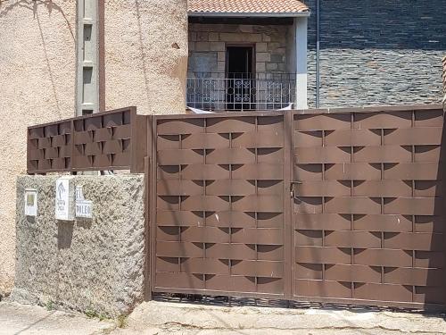 una puerta de madera frente a un edificio en CASA RURAL EL TOLEO, en Hoyos del Espino