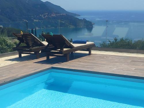 SinarádesにあるVilla Vardia-Amazing Seaviews with heated poolの水辺の景色を望むスイミングプール(椅子2脚付)