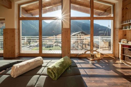 a room with a large window with a view of the mountains at Genusshotel Alpenblick in Längenfeld