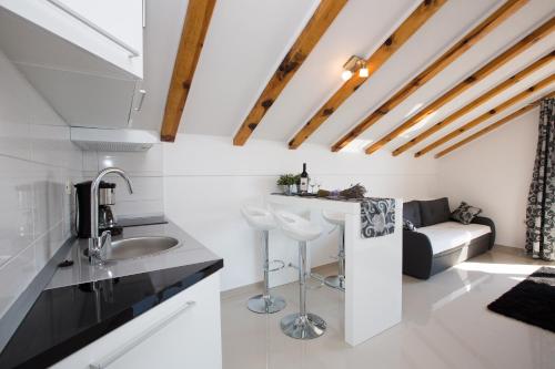 eine Küche mit einem Waschbecken und einem Sofa in einem Zimmer in der Unterkunft Mediterranean Sunset Apartments in Cavtat