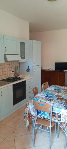 a kitchen with a table and chairs and a kitchen with white cabinets at ESTATE IN SARDEGNA in La Caletta