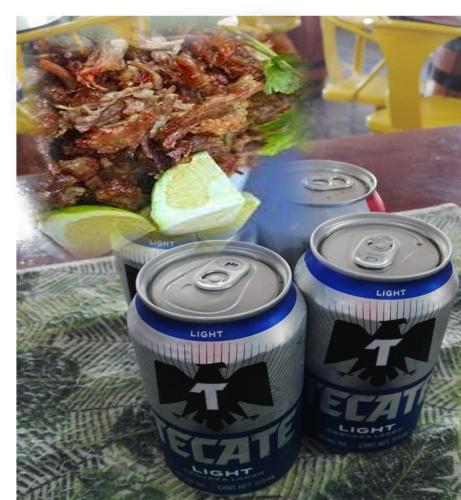 three cans of soda sitting on a table with food at La Maja Suites in Villahermosa