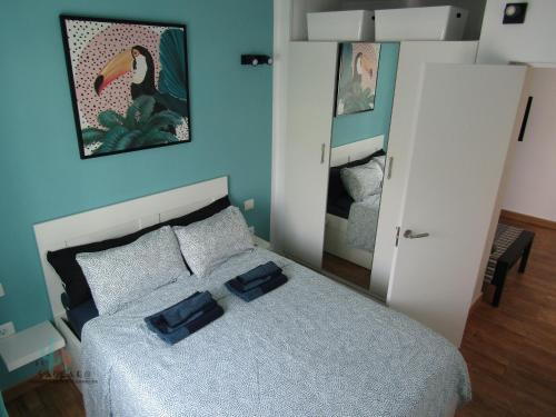 1 dormitorio con 1 cama con 2 almohadas azules en El Saguaro, en Arona