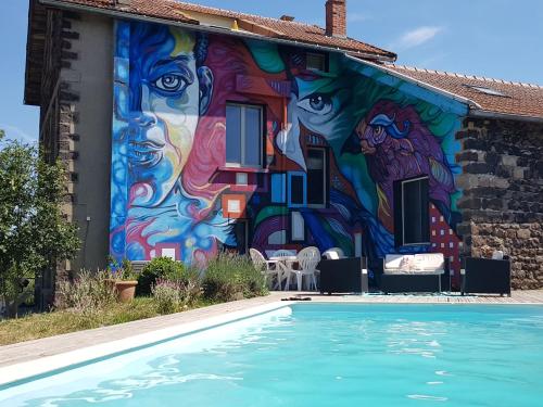 een muurschildering aan de zijkant van een huis met een zwembad bij Gîte Le Roman d'Alleyrac (ciel bleu) in Alleyrac
