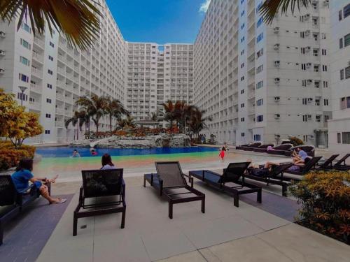 a group of people sitting in chairs in front of a pool at Shore Residence D1,shortwalk MALL OF ASIA near airport wifi in Manila