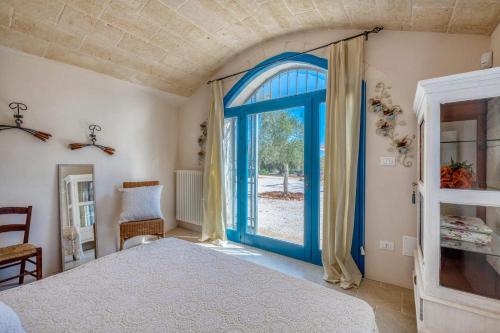 - une chambre avec une porte bleue et une fenêtre dans l'établissement Villa Trullo Didi by Villa Plus, à Ceglie Messapica