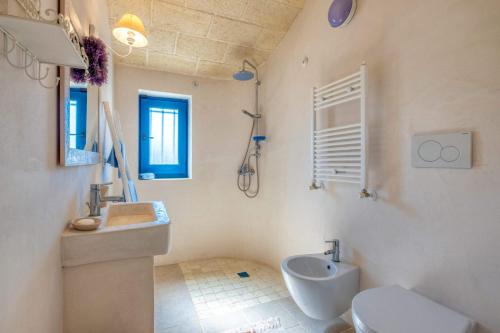 La salle de bains blanche est pourvue d'un lavabo et de toilettes. dans l'établissement Villa Trullo Didi by Villa Plus, à Ceglie Messapica